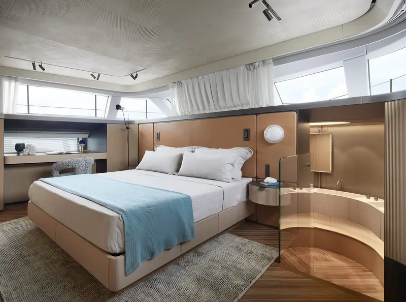 A guest cabin with a built-in desk and ensuite visible through a glazed screen.