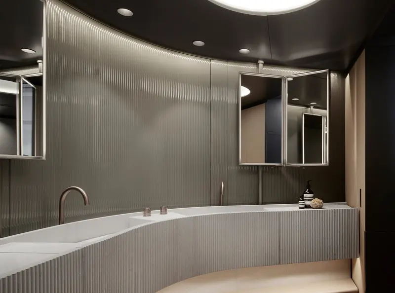 An ensuite bathroom with a freestanding tub set against ribbed panelling.