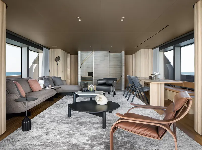 The main saloon runs windows-to-windows with no central pillar break, so the sofa arrangement is lit from both sides of the beam.