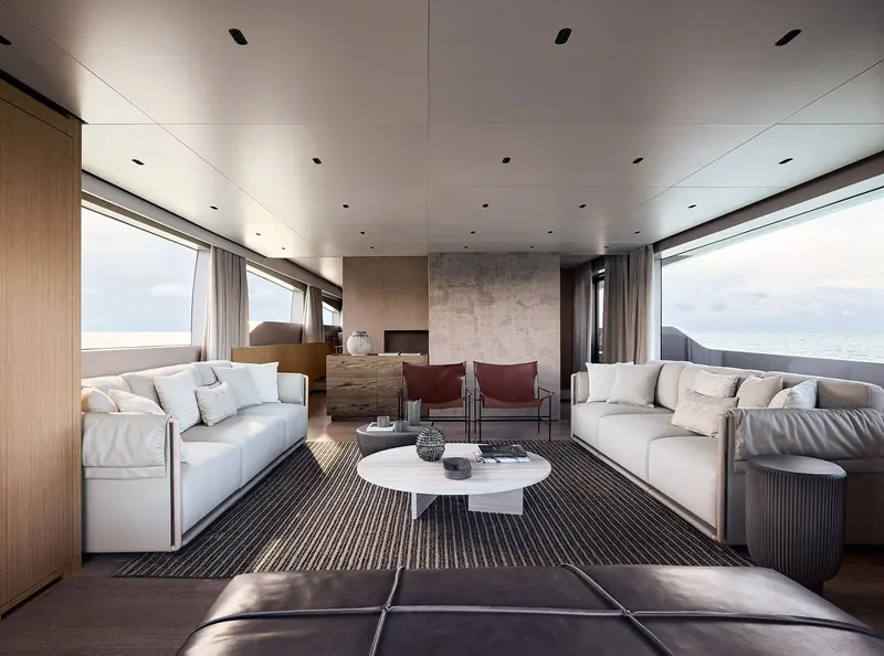 The main-deck saloon, twin sofas in cream and burgundy around a round coffee table.