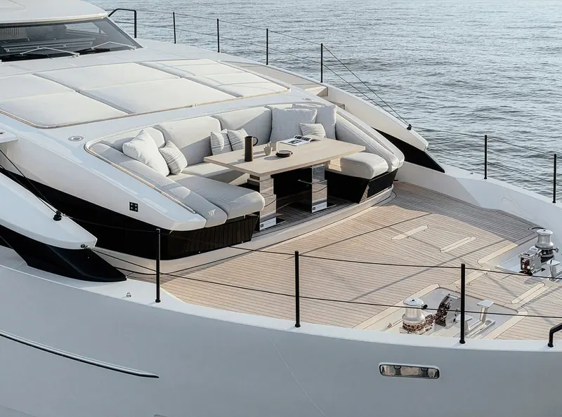 Overhead of the flybridge lounge and dining area, teak decking and a full C-shaped sofa.