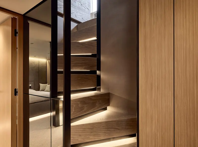 The internal staircase in warm timber, connecting the guest accommodation deck.