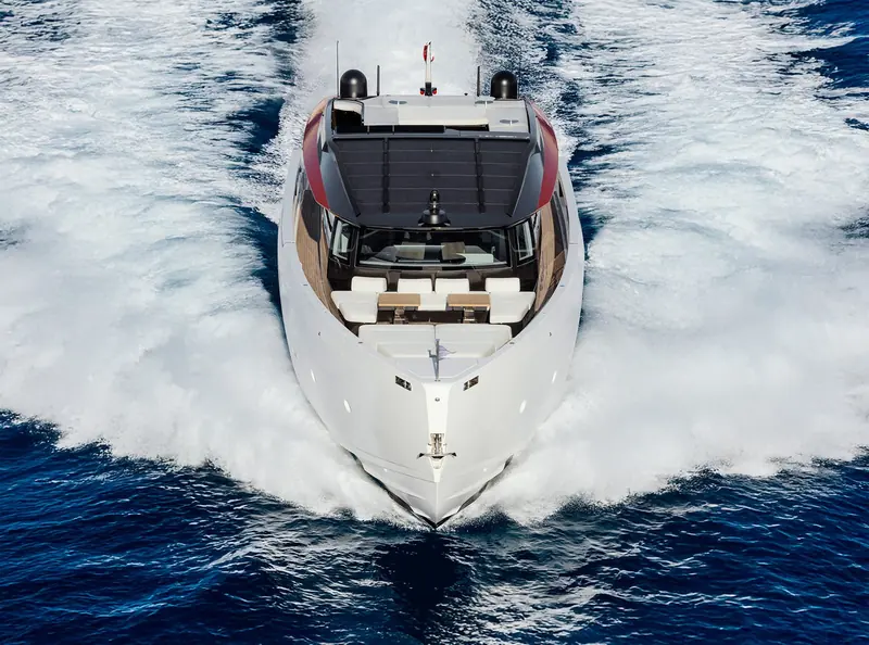 The Sanlorenzo SP92 head-on at speed, bow wave breaking either side and the open cockpit visible through the windscreen.