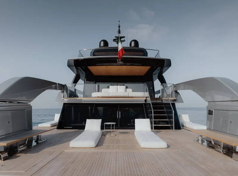 The aft flybridge sun pad beneath the distinctive wing-shaped hardtop supports.