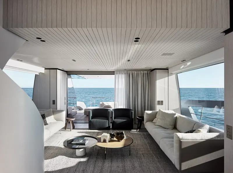 A second saloon view showing the sectional sofa and full-beam window looking aft.