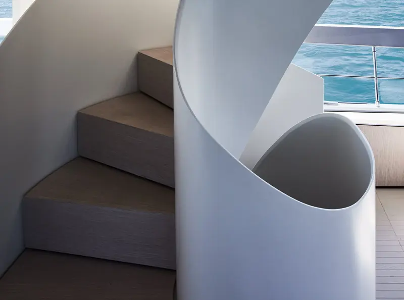 The SX76's sculptural spiral staircase in pale render, connecting the flybridge to the deck below.