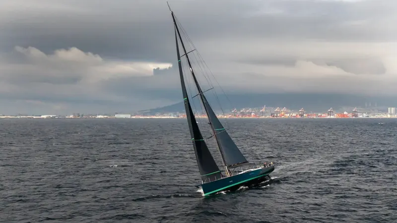Fortissimo under sail, her dark green hull and performance rig visible against open water.