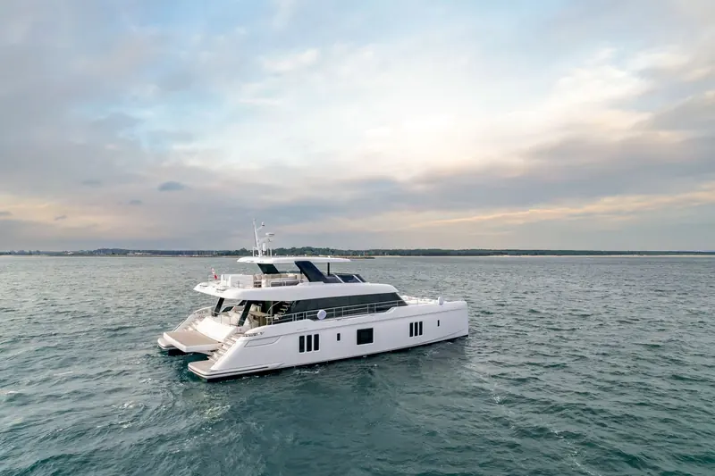 The 80 Sunreef Power Eco at dusk, solar-panelled hull sides catching the last light.