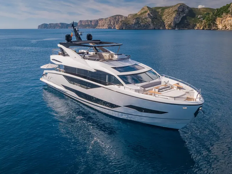 90 Ocean from directly overhead at speed, the full deck plan visible in one frame: foredeck sunpad, hardtop, flybridge and cockpit.