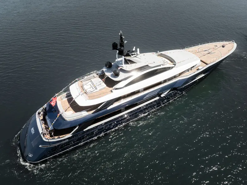 An aerial three-quarter view over the Bosphorus showing the full deck plan, from the foredeck lounge forward to the aft pool and beach-club area.