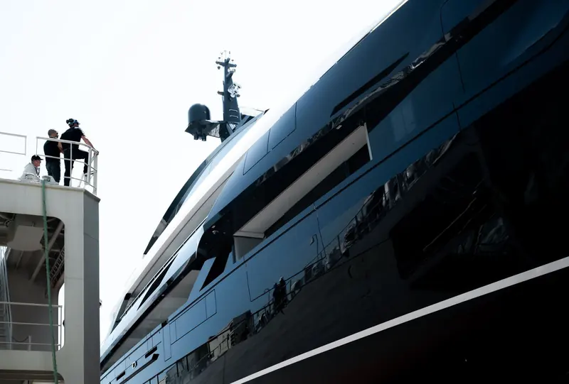 A further broadside pass showing the hull's reverse sheer and stepped superstructure in full profile.