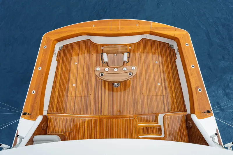 The Viking 82 Convertible cockpit from directly overhead, showing the mezzanine seating and covering boards in teak.