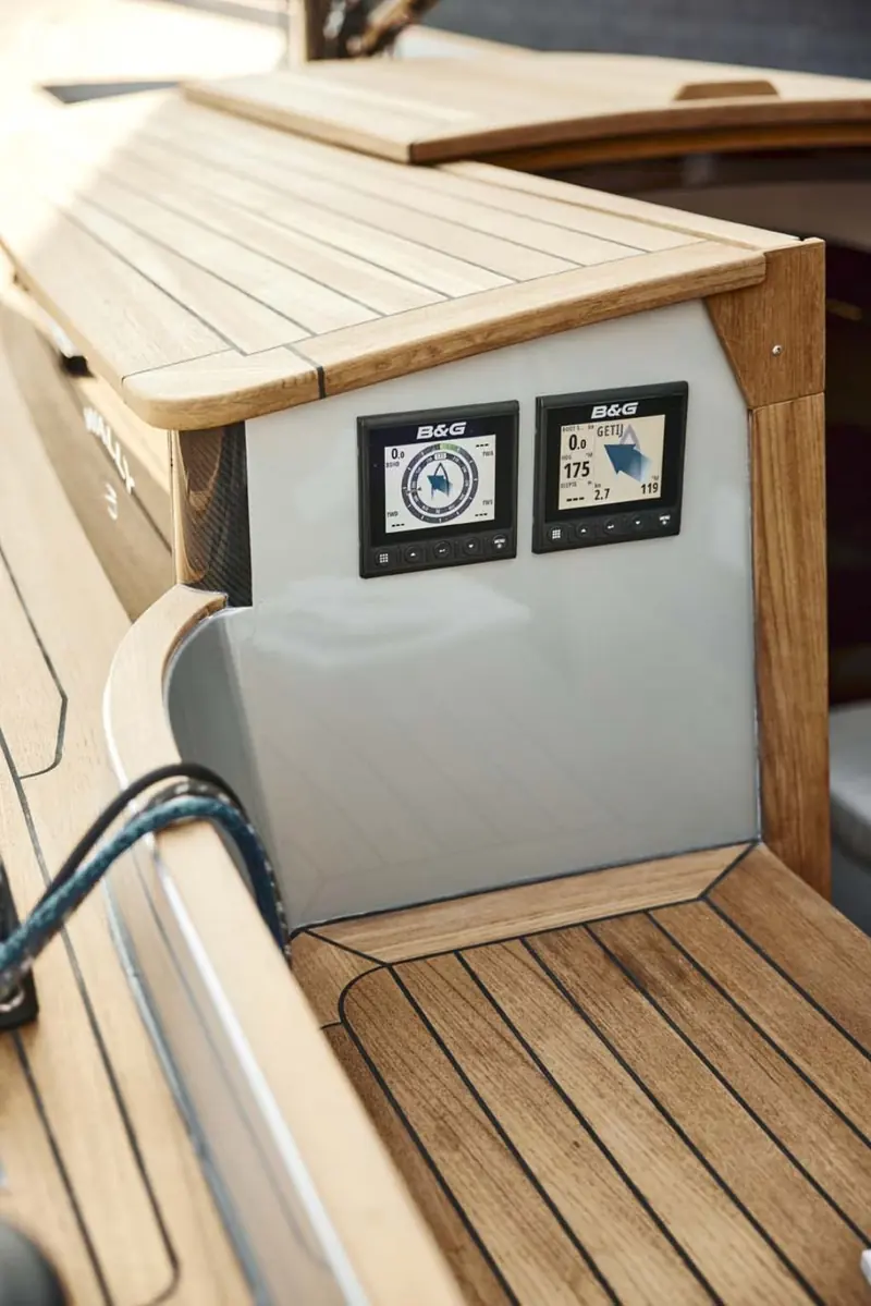 The teak-topped cockpit coaming and simple instrument binnacle show a boat fitted for sailing, not for entertaining at anchor.
