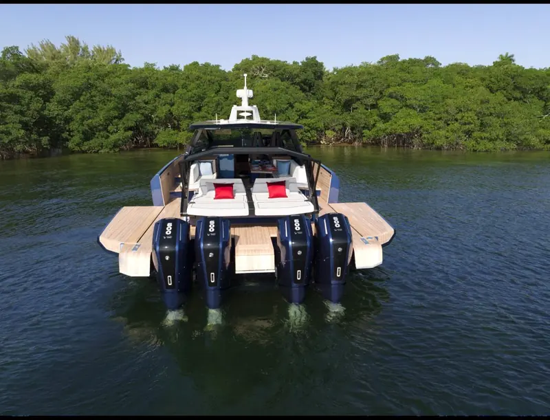 Stern view at rest showing the quad outboard installation and the teak-laid swim platform between them.