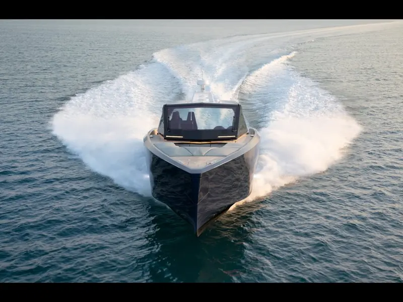 Hard-turning bow-on shot, the deep-V hull digging in and throwing a wide sheet of spray either side.