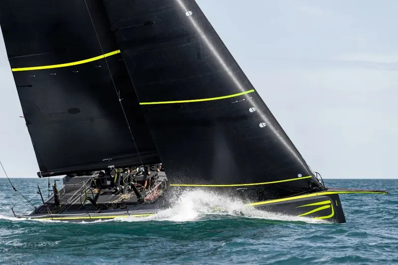 Two black-hulled Wallyrockets racing bow to bow, sails sheeted flat and crew braced against the spray as both boats bury their bows.