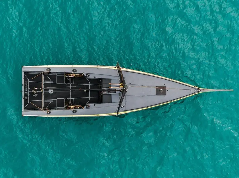 Overhead view of the bare foredeck and cockpit layout, showing the flush deck and narrow waterline beam that define the design.