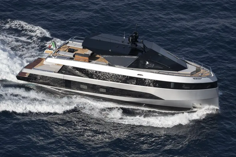 Wallywhy200 under way at speed, her open transom garage and low, sharply creased superstructure visible in three-quarter profile.