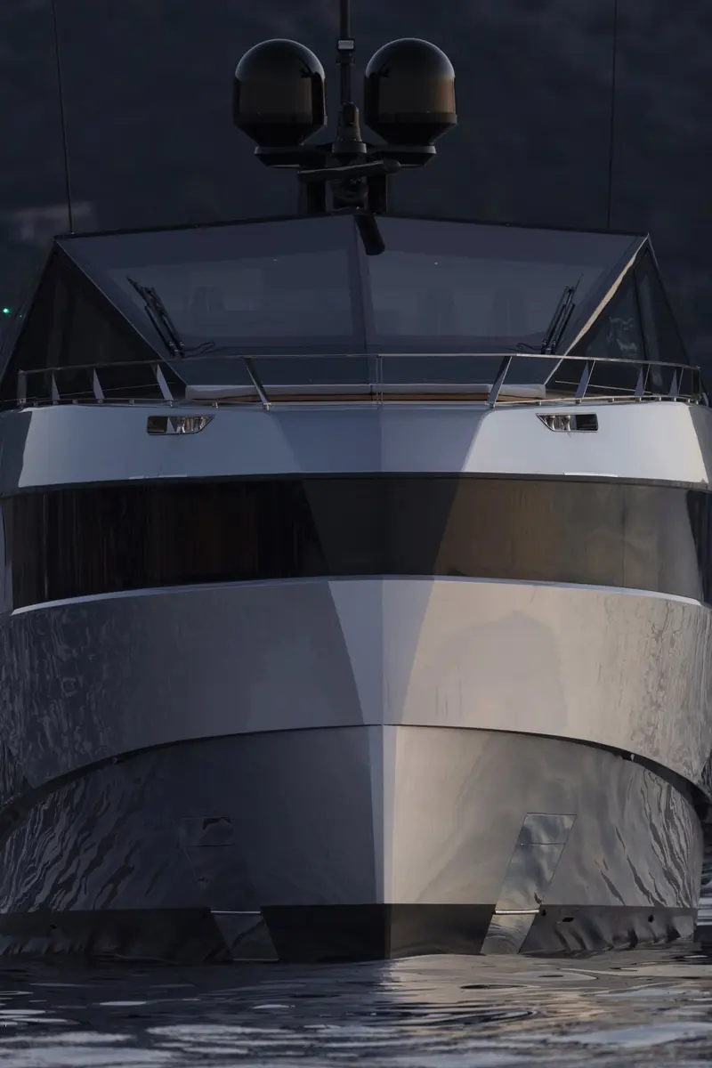 Stern-on at rest, the full-beam transom door raised to shelter an aft cockpit lounge fitted with folding chairs and a table.