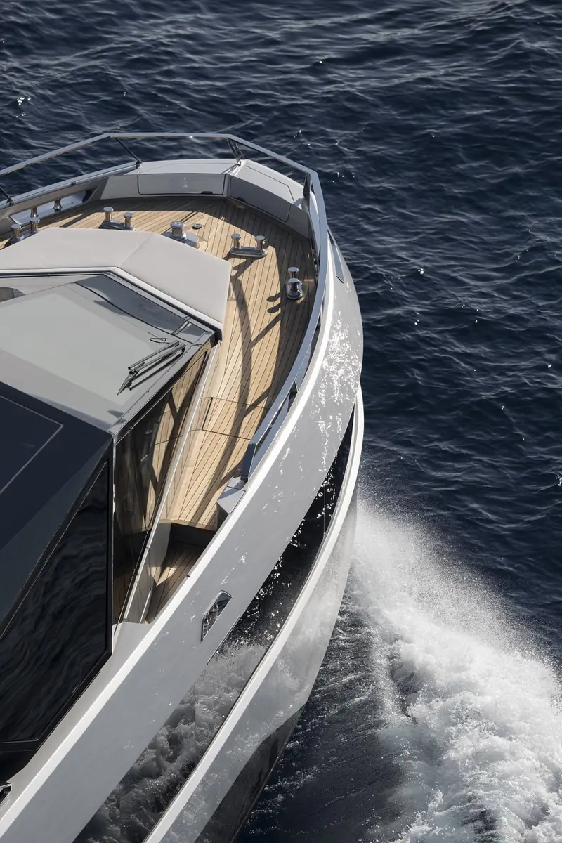 Running hard from astern, the twin outboard-style drives throwing a wide, aerated wake typical of this hull's planing speed.