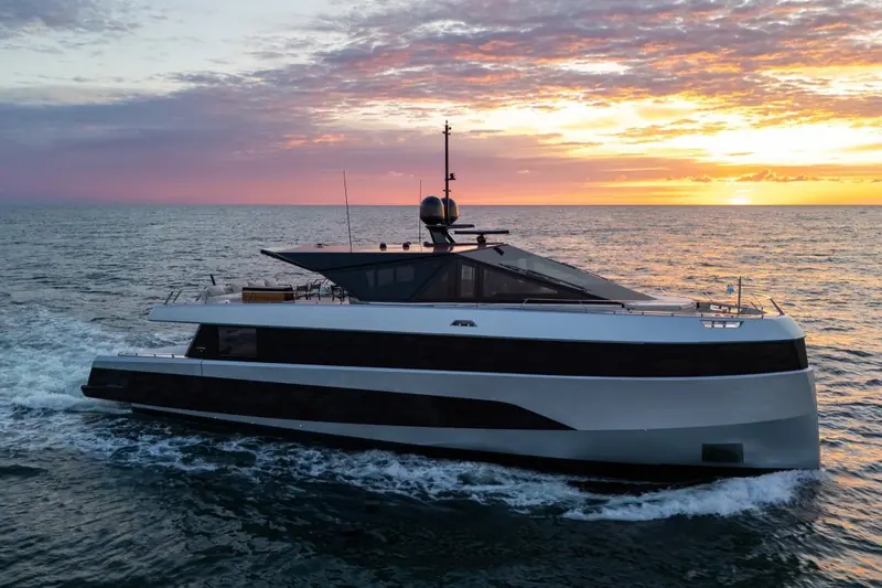 At rest at dusk, hull lit warm by the setting sun with the transom garage door lowered for boarding.