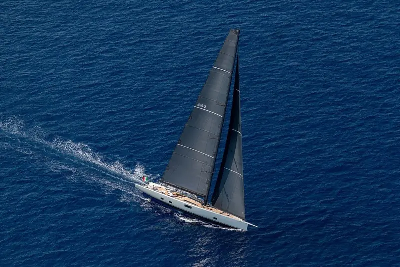 Sailing away close-hauled under mainsail and headsail, the low, flush-decked profile that marks Wally's sailing yachts visible from astern.