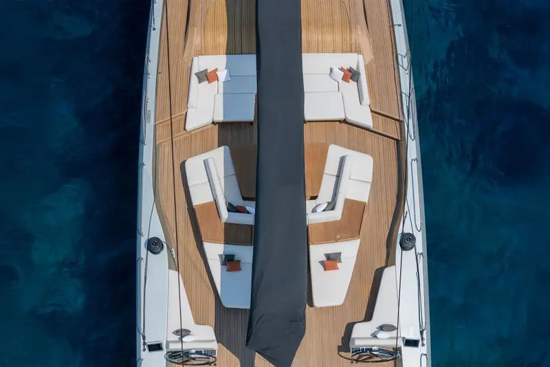 Overhead view of the cockpit under sail, showing the flush deck layout and the winches set low and out of the way of guest seating.