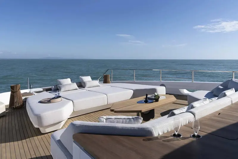The foredeck lounge and sunpads, reached via the walkaround side deck rather than cutting back through the saloon.