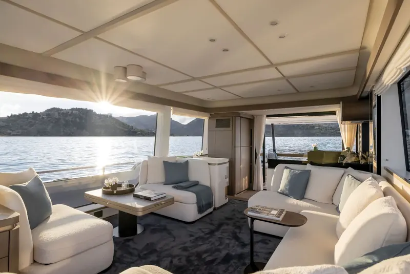The saloon at sunset, its wraparound glazing putting the whole anchorage on display from the U-shaped seating.