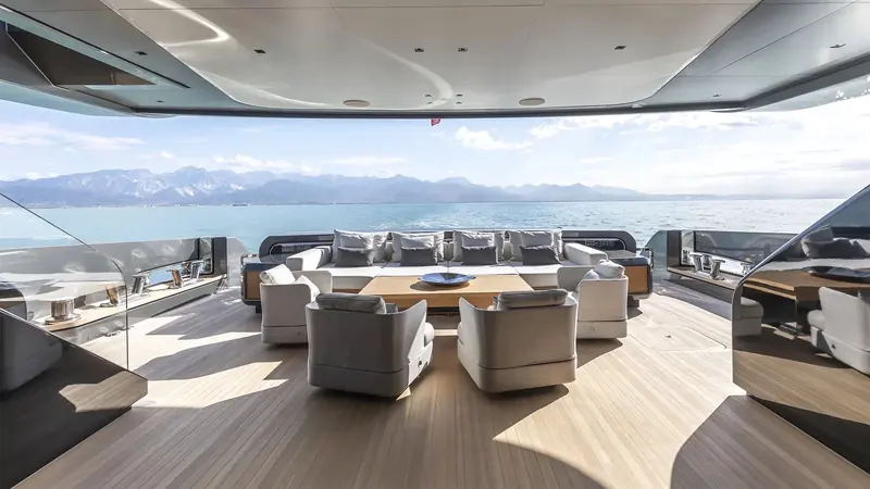 Upper deck seating looking aft over the wake, mountains behind the coastline visible for miles in clear conditions.