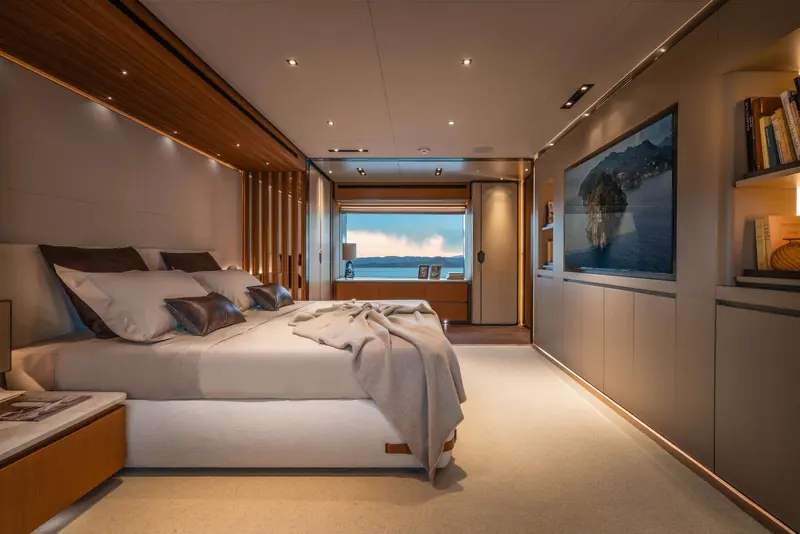 One of the T52's guest cabins, finished in warm timber panelling with a full-height window framing the sea - the interior work of Francesco Paszkowski's studio.