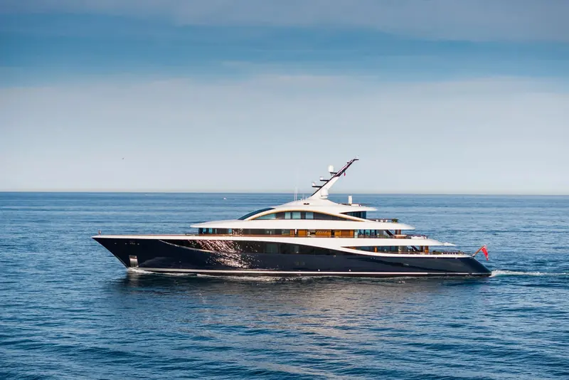 Faith under way in Antibes, the dark hull and full-beam glazing of RWD's exterior design catching the afternoon light.