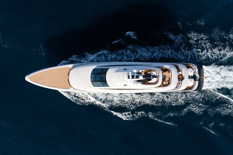 Running at speed from directly overhead, showing how far forward the helipad sits and how little superstructure interrupts the foredeck.