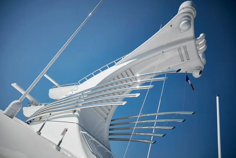 A detail of the mast and radar arch from below, its fanned stainless supports against a clear sky.