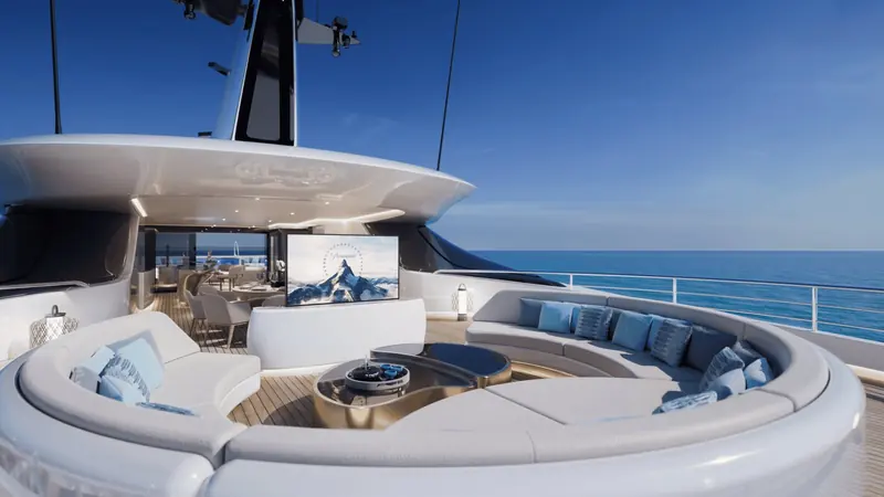 The aft skylounge's circular sofa wraps a sunken fire-pit table, with a fold-out screen for outdoor cinema nights and the dining table visible through the open doors beyond.