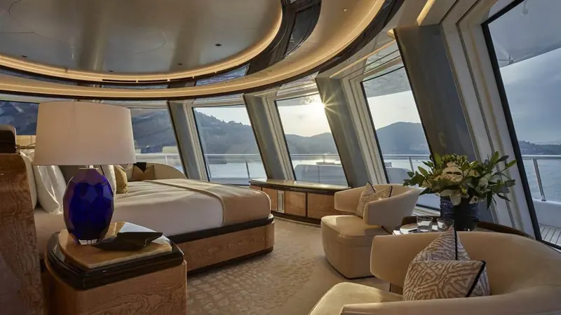 A guest stateroom wrapped in glass, positioned for a sunset view rather than privacy.