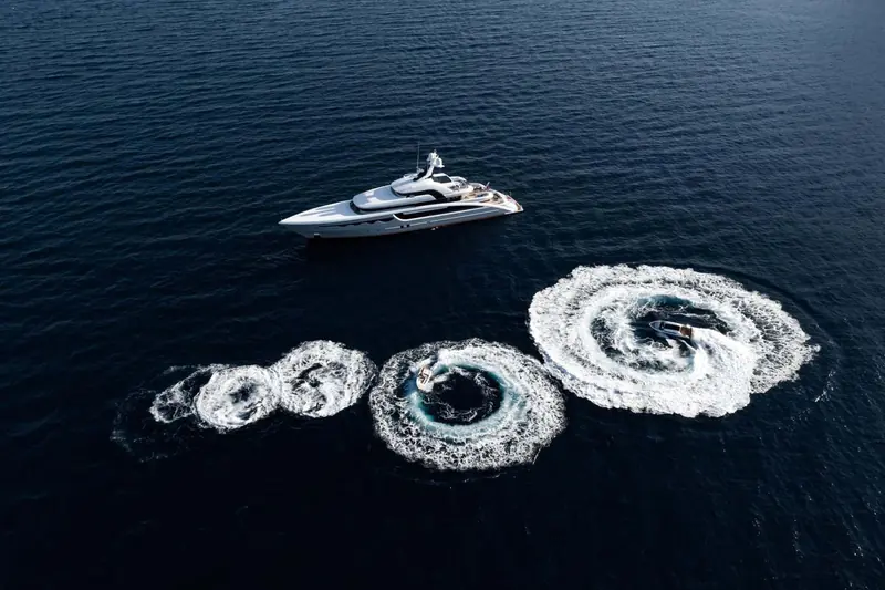 Concentric wake patterns left by a tender circling back to the yacht, shot from directly overhead.