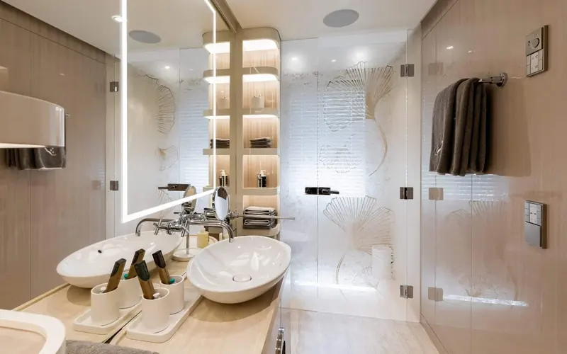One of the guest bathrooms, book-matched stone panelling behind twin countertop basins.