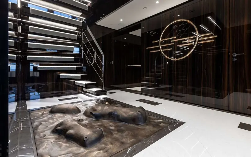 The main stairwell, a circular art installation set into the dark wood panelling beside the treads.
