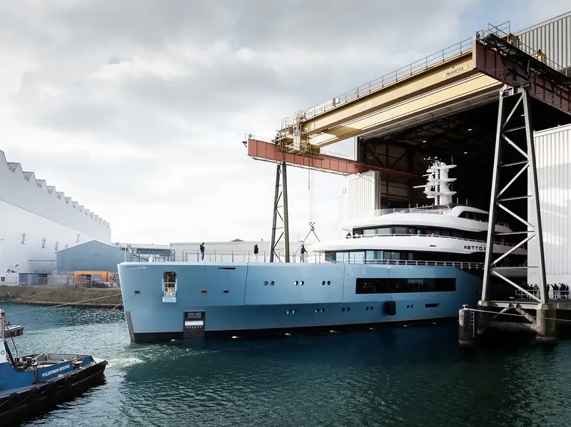Netto II, the delivered Amels 80, coming out of the build shed on a submersible barge at the Damen yard in Vlissingen, the moment every semi-custom Amels hull passes from shed to water.