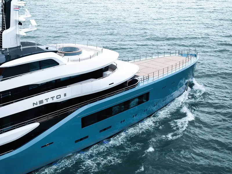 Under way with her name visible on the bow, showing the long, near-vertical hull sides and low superstructure that keep an Amels 80 inside commercial load-line rules other 80-metre-class yachts trade away.