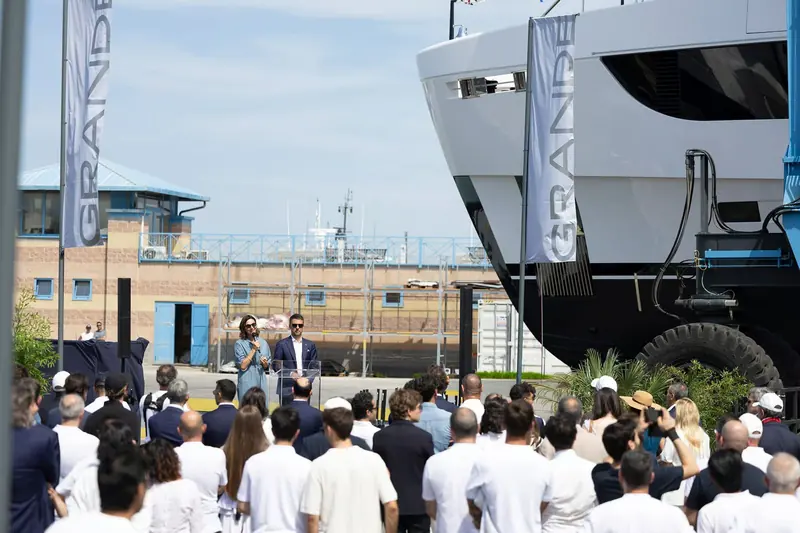 Guests and yard staff gather dockside under the hull for the naming ceremony.