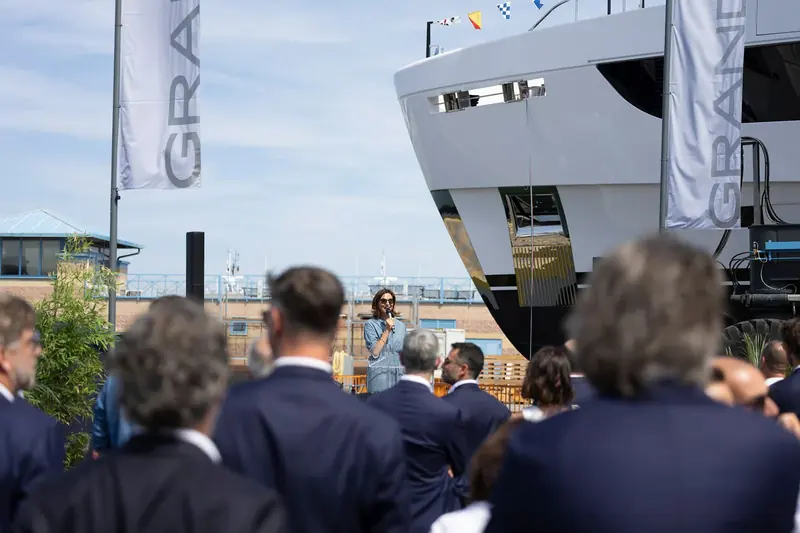 Azimut executives address the crowd from the quay as the hull waits behind them ahead of the launch.