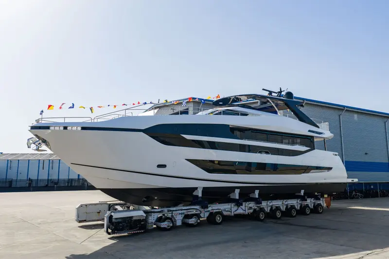 On her transporter trailer ahead of launch, the Manhattan 94 flies a string of international code flags the length of her foredeck.