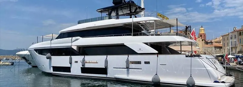 The stern view shows the fold-out beach club platform and the bow-garage crane the yacht carries for a second tender.