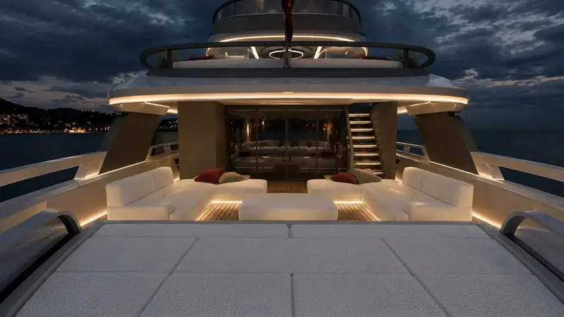 The aft deck lounge by night, rendered with the low, integrated lighting that runs through every exterior space in the concept.