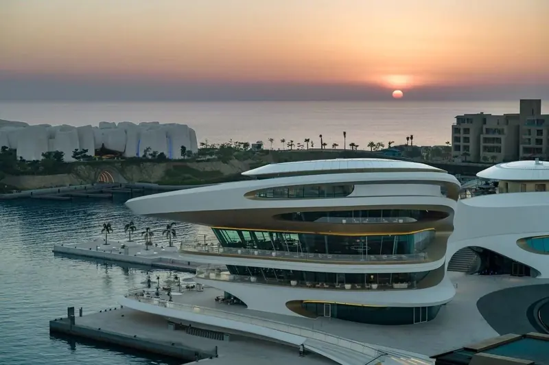 The yacht club at sunset, with AMAALA's Corallium marine-life institute on the shoreline beyond
