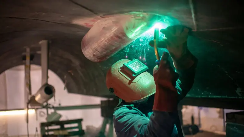 A welder works on a structural modification, part of the metalwork Amico & Co runs in-house rather than subcontracting.