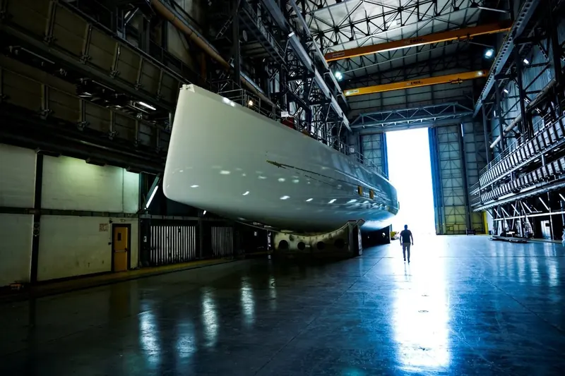 Argo 54's bow inside the shed, bay doors open. Four named studios - Kouyoumdjian, Rob Doyle, Mark Whiteley and, per BOAT International, Lorenzo Argento - share the design credits.