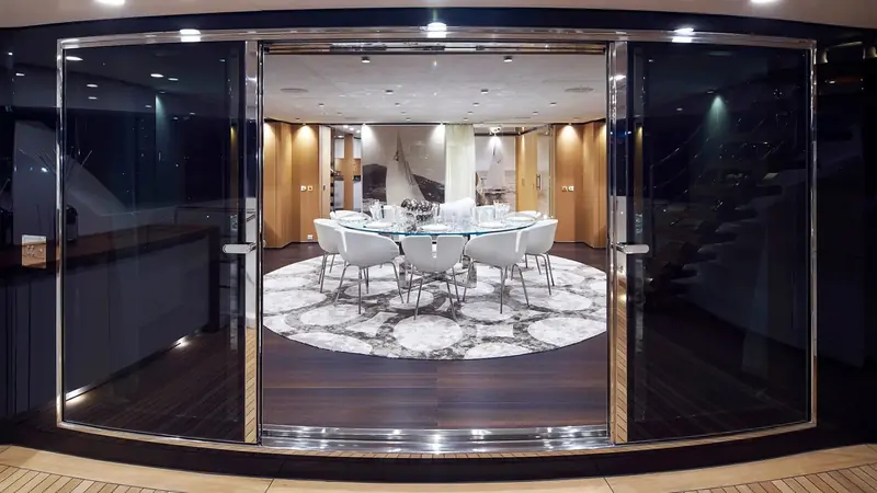 The upper-deck formal dining area, linked to the main saloon below by a stainless-steel staircase.